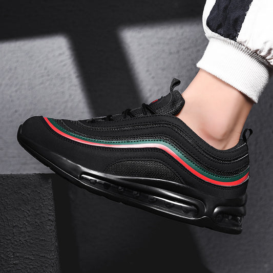 Black sneaker with red and green accents worn by a person on a dark background