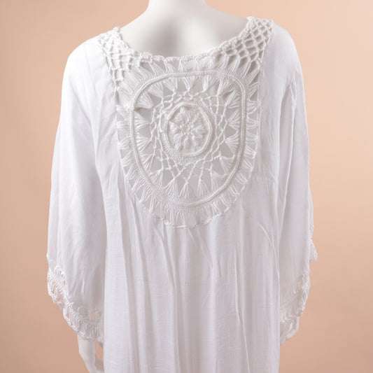 White blouse with intricate lace detailing on a beige background