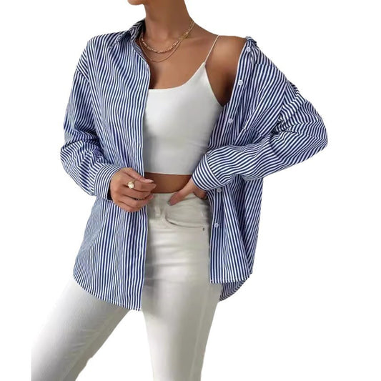 Woman wearing a blue and white striped shirt over a white top and pants on a white background