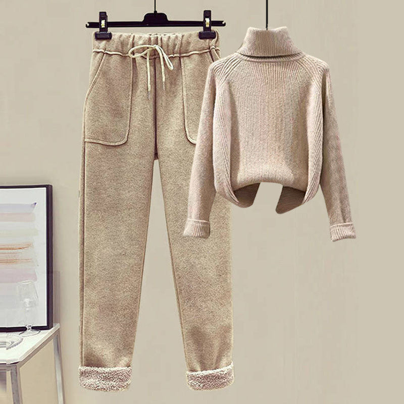 Beige sweater and jogger pants set on a hanger against a plain background