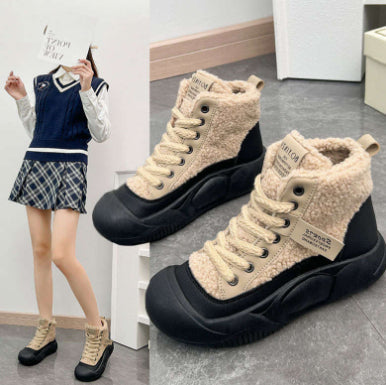 Pair of high-top sneakers with beige and black color scheme on a gray floor.