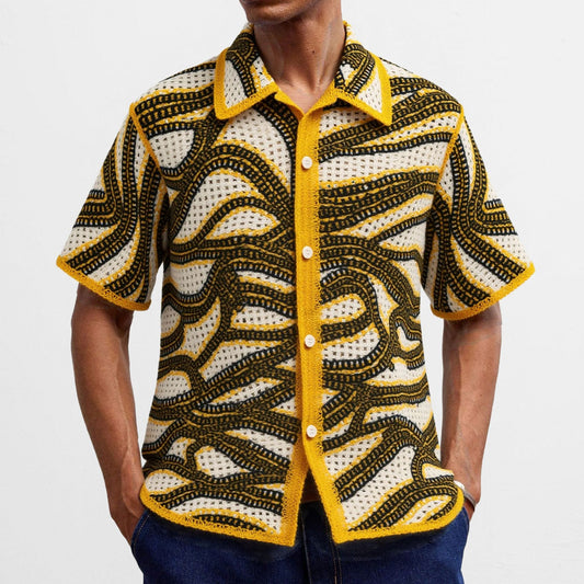Person wearing a patterned shirt with yellow accents on a plain background