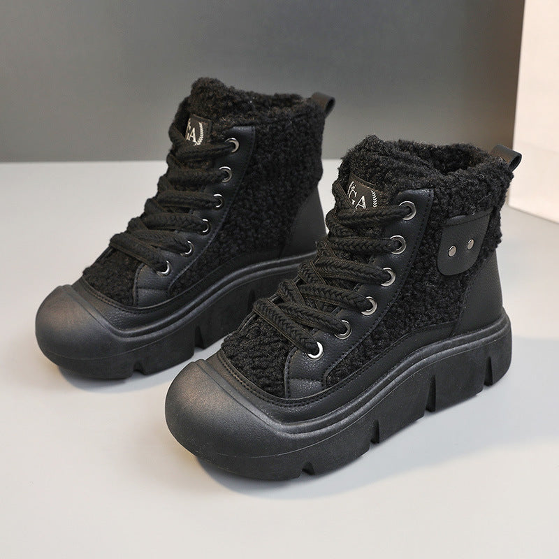 Pair of black winter boots with fuzzy texture on a white background