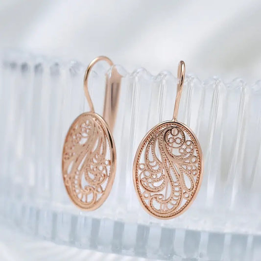 Rose gold earrings with intricate designs on a white background