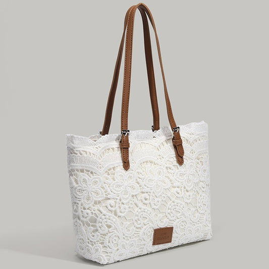White lace tote bag with brown straps on a gray background