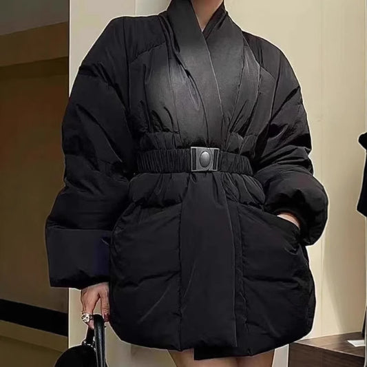 Person wearing a black puffer coat with a belt in an indoor setting