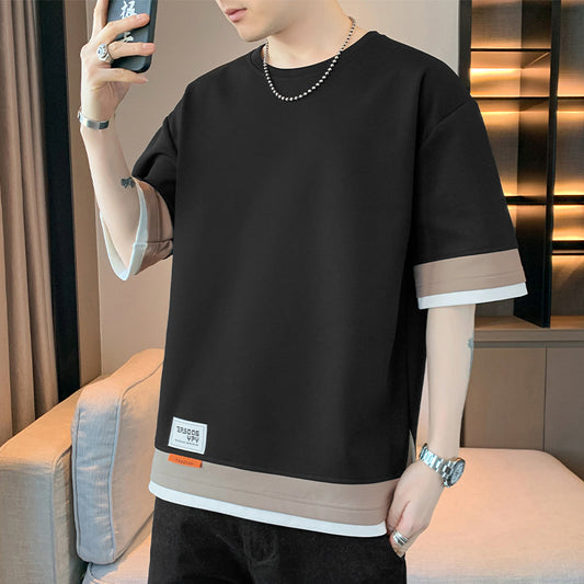 Person wearing a black and beige outfit with a blurred background