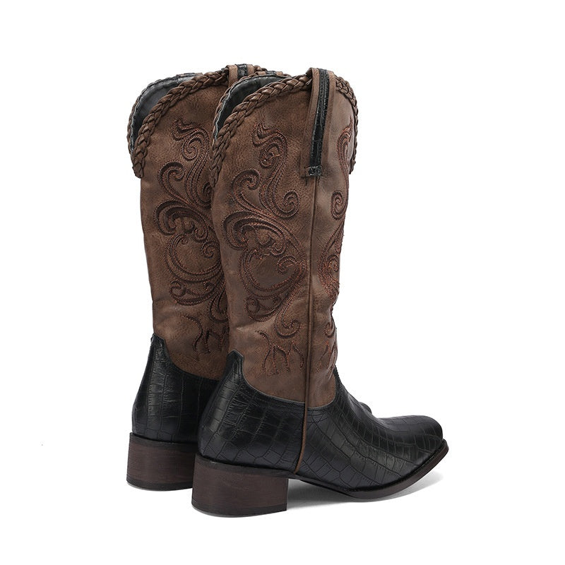 Pair of brown cowboy boots with intricate designs on a white background