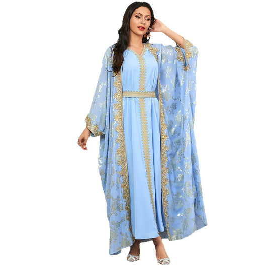 Woman wearing a light blue dress with gold embroidery on a white background