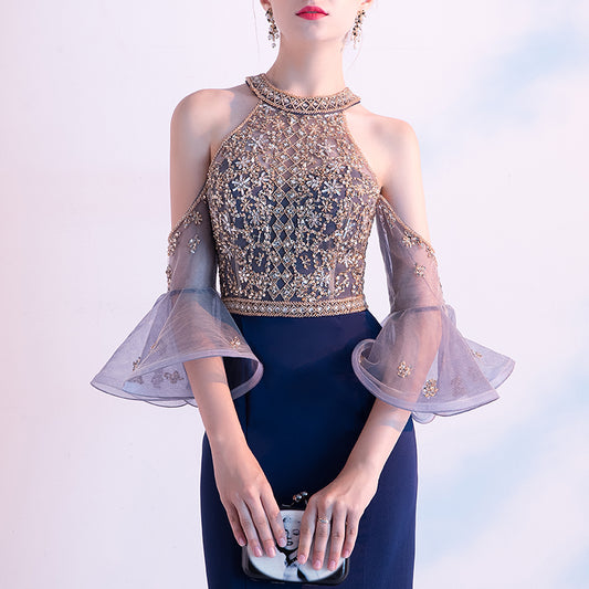 Elegant outfit with a detailed top and dark pants on a light background