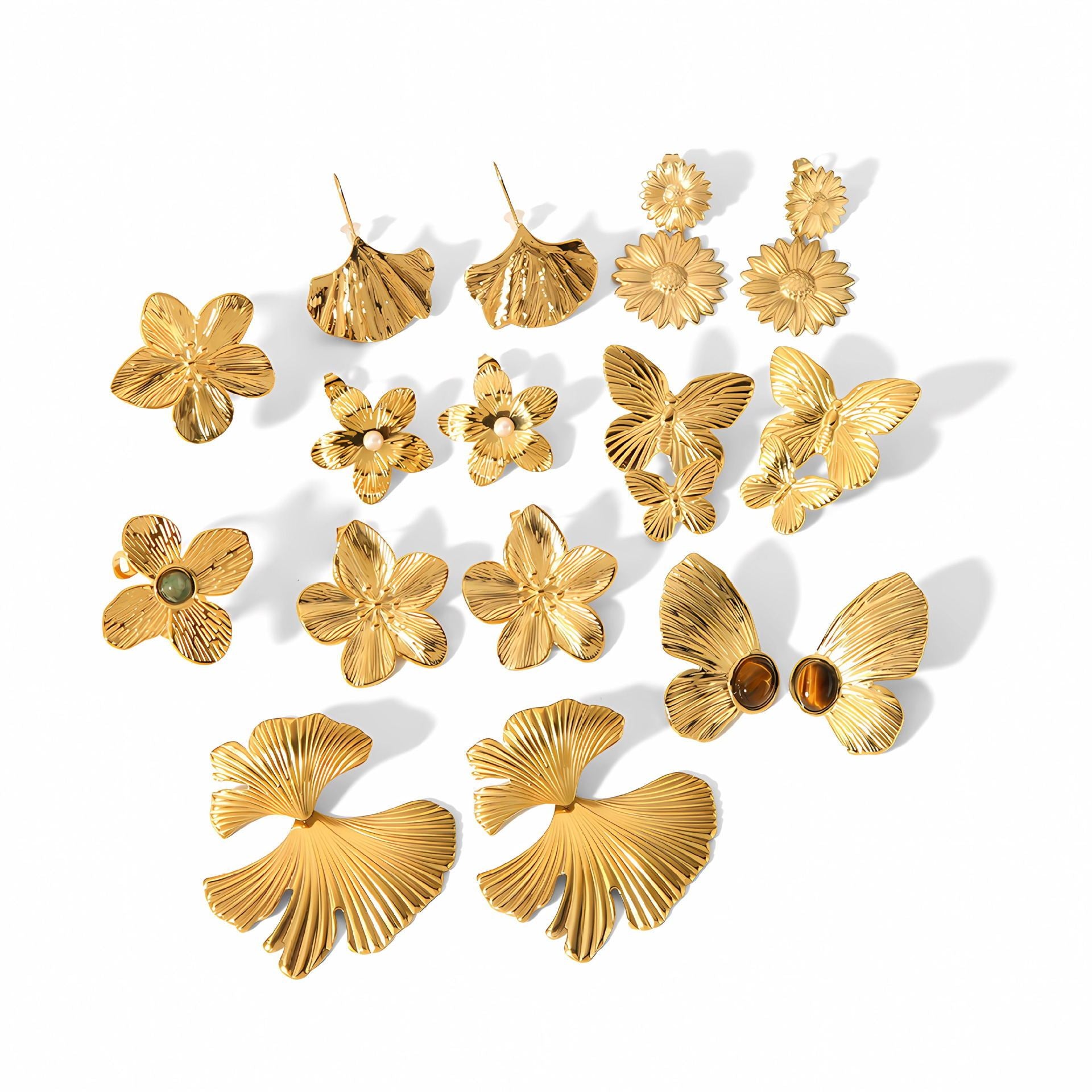 Collection of gold floral and butterfly earrings on a white background