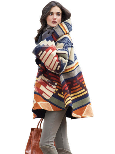 Woman wearing a colorful patterned coat on a white background
