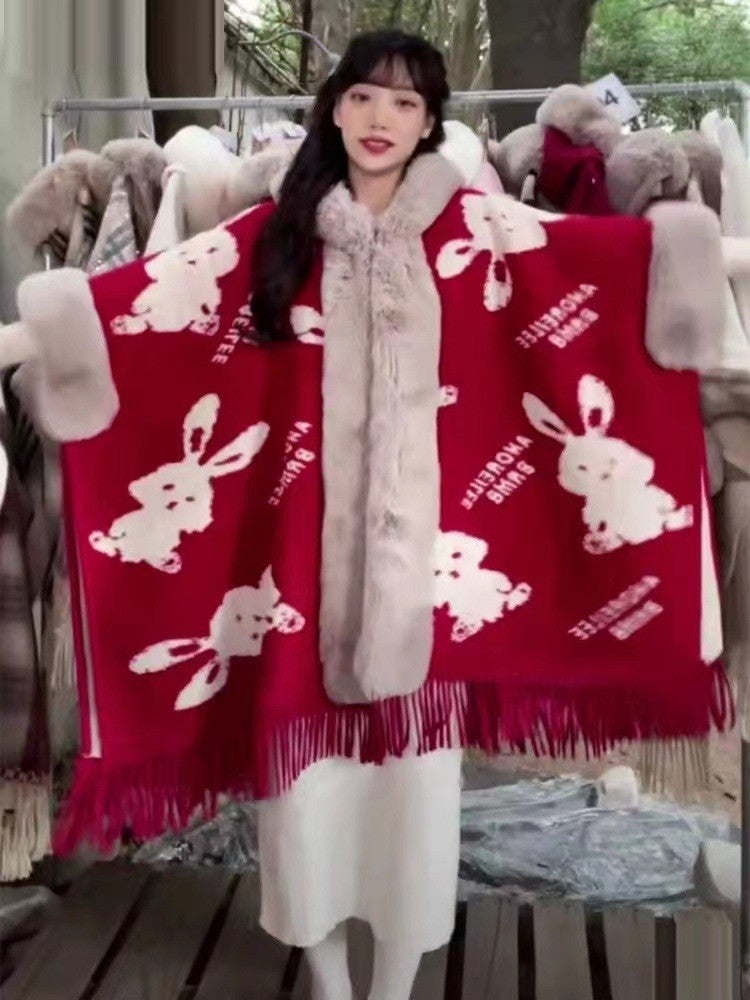 Person holding two red scarves with white rabbit designs in a store setting