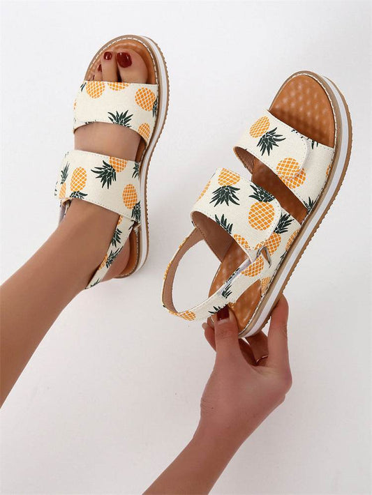 Pineapple-patterned sandals on a white background
