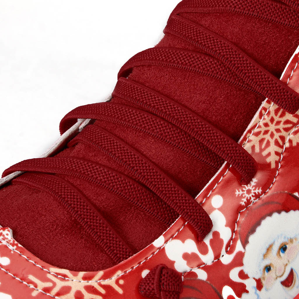 Close-up of red shoelaces on a Christmas-themed sneaker with Santa Claus design.