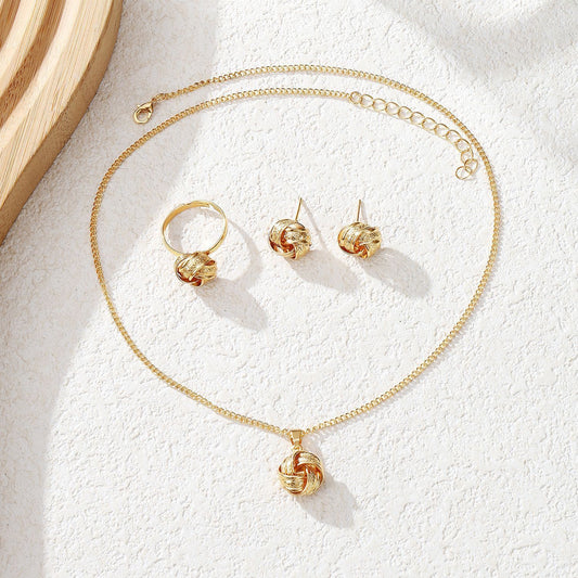 Gold jewelry set including necklace, ring, and earrings on a light background
