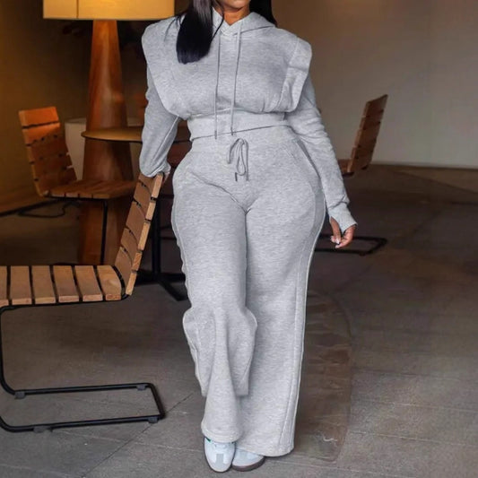 Person wearing a gray tracksuit in an indoor setting