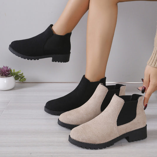Black and beige ankle boots on a neutral background
