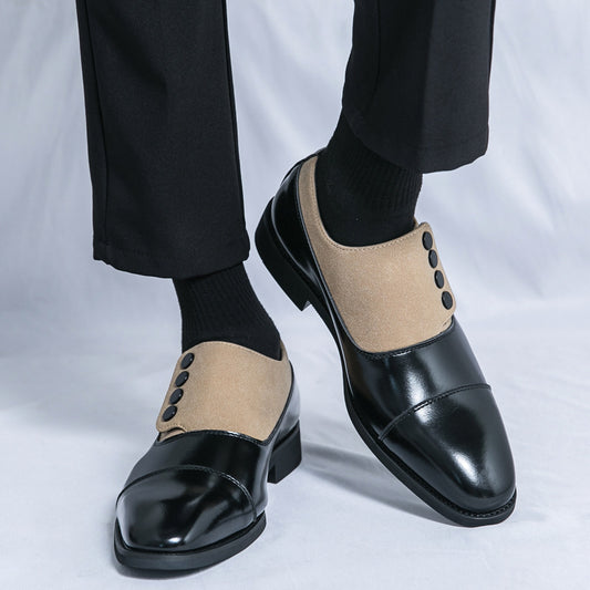 Black and beige dress shoes worn with black pants and socks on a light gray background