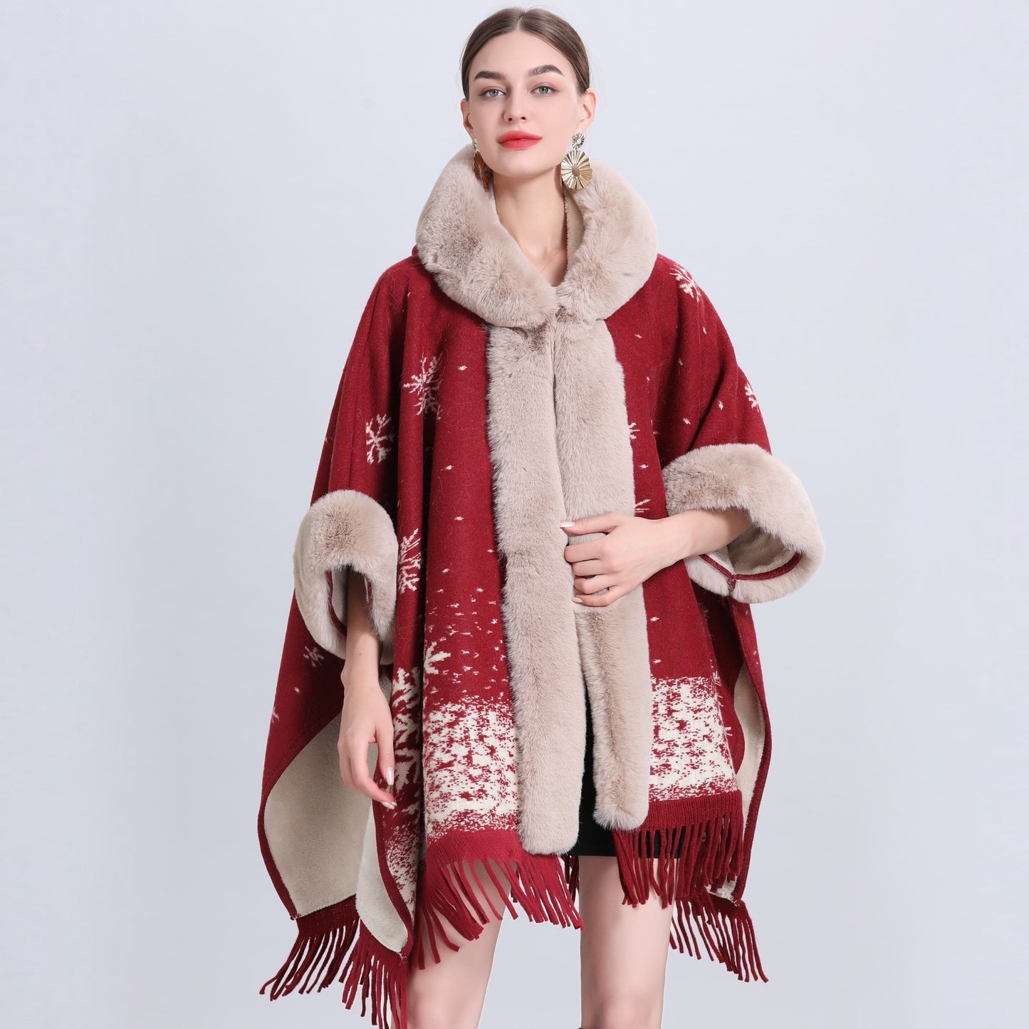 Red poncho with fur trim and fringe on a white background