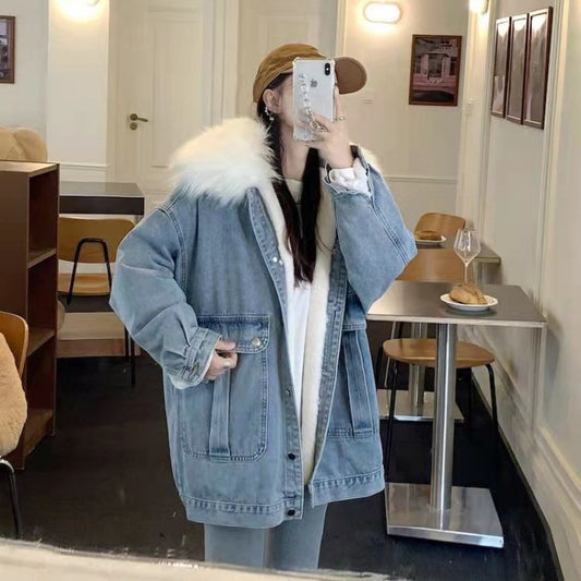 Person wearing a denim jacket with fur hood in a cafe setting