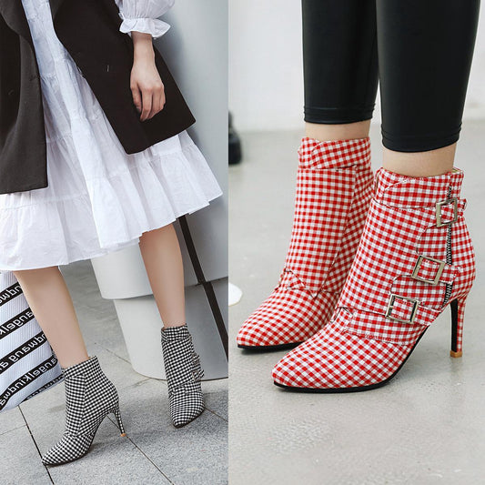 Red and white checkered boots with high heels on a gray floor.