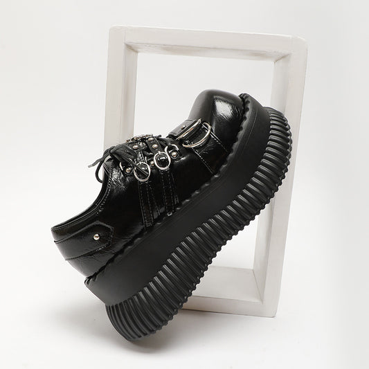 Black platform shoe with detailed design on a white background