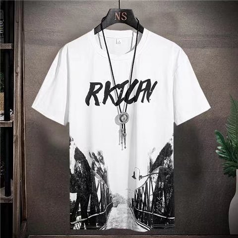 White t-shirt with black graphic design and text on a hanger against a gray wall.