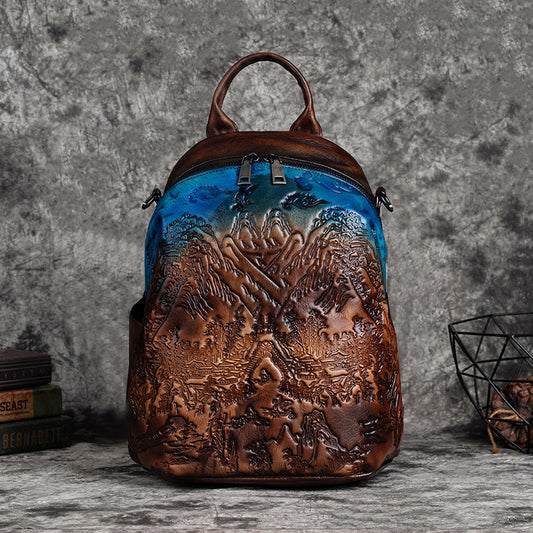 Brown leather backpack with mountain design on a gray background