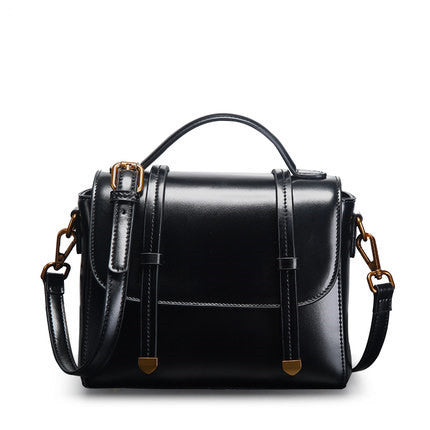 Black handbag with gold accents on a white background