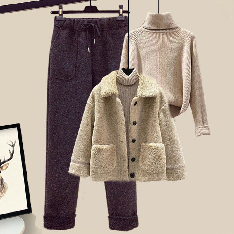 Beige coat, dark pants, and beige sweater on hangers against a neutral background