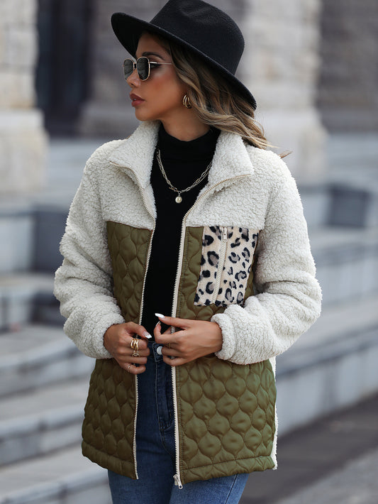 Woman wearing a stylish quilted jacket with leopard print accents outdoors.