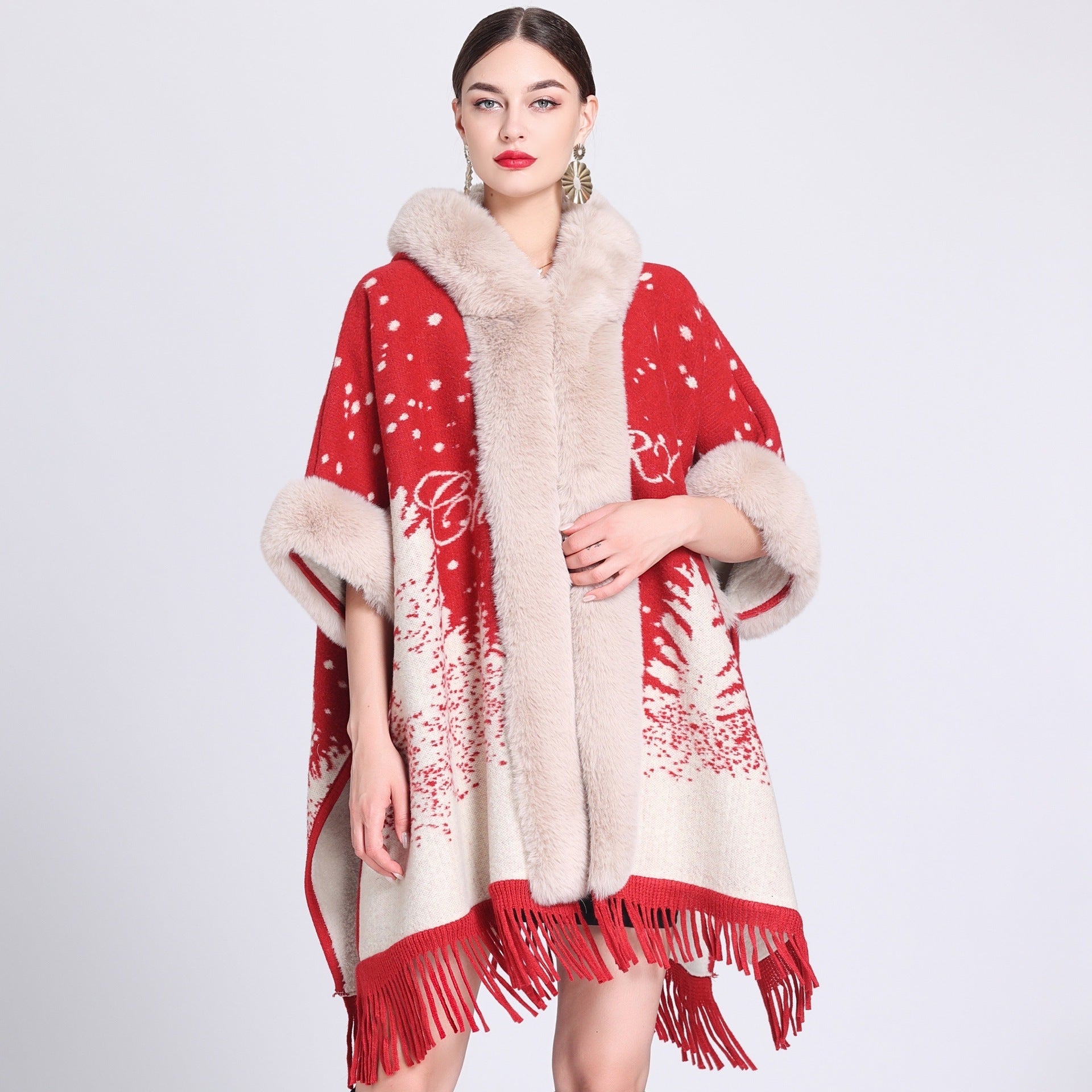 Woman wearing a red and beige patterned poncho with fur trim on a white background