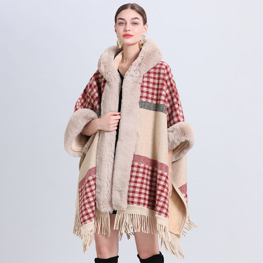 Woman wearing a plaid poncho with fur trim on a light gray background