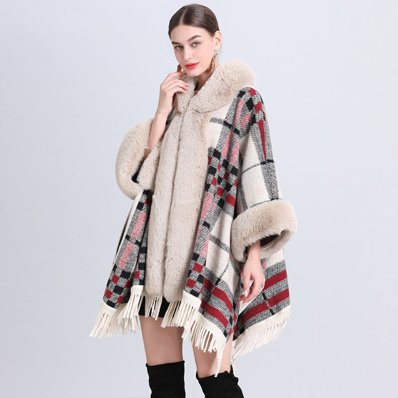 Woman wearing a plaid poncho with fur trim on a light gray background