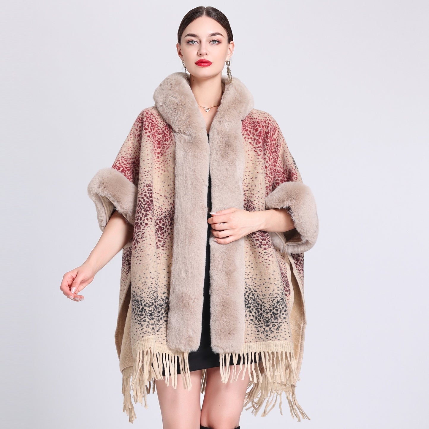 Woman wearing a patterned poncho with fur trim on a light gray background