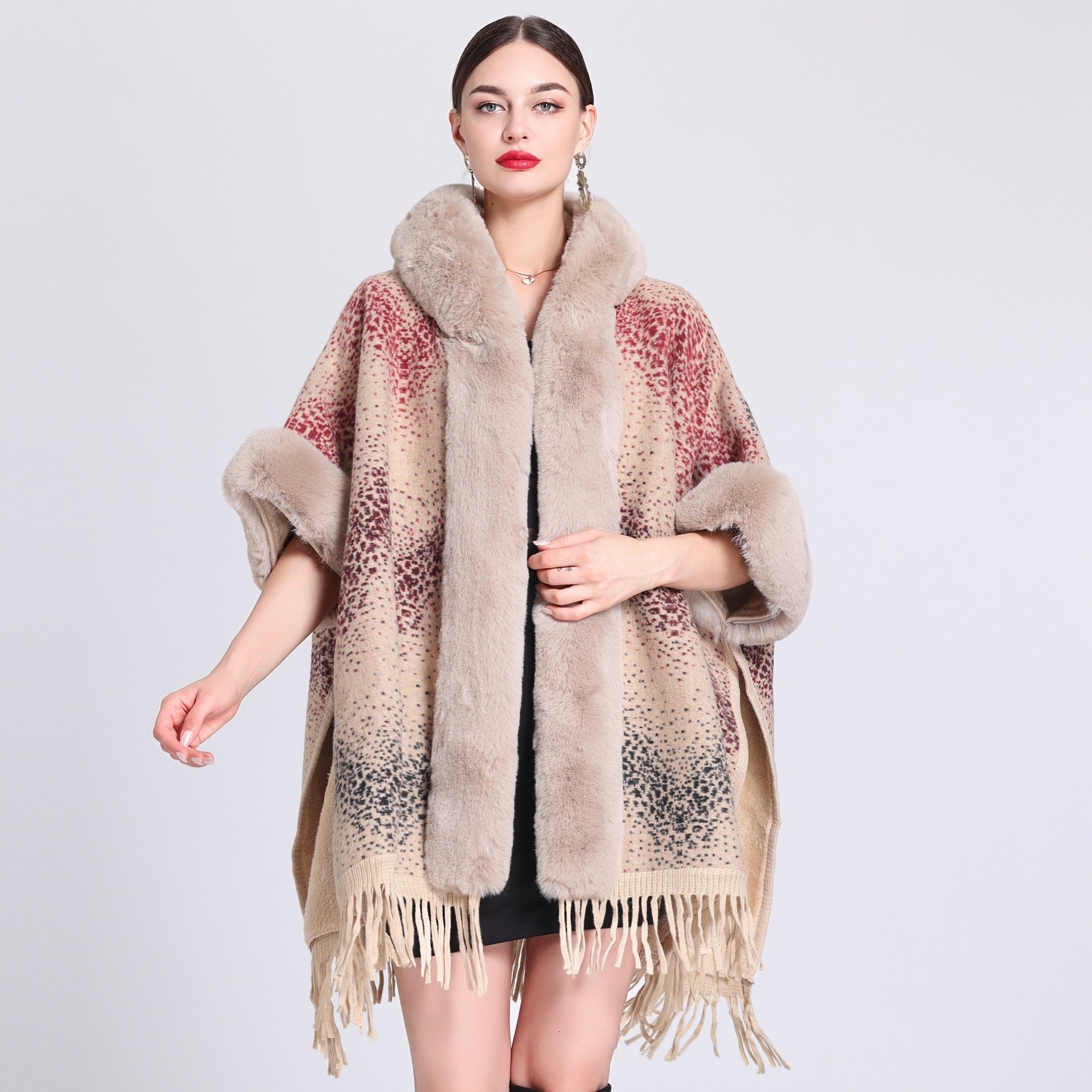 Woman wearing a patterned poncho with fur trim on a light gray background
