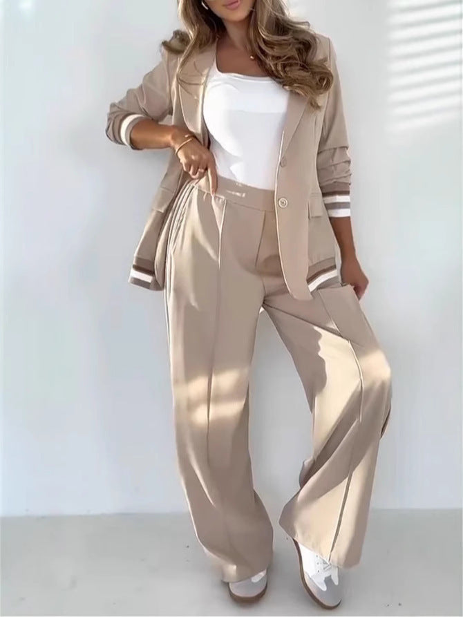 Woman wearing a beige suit with a white top against a white background