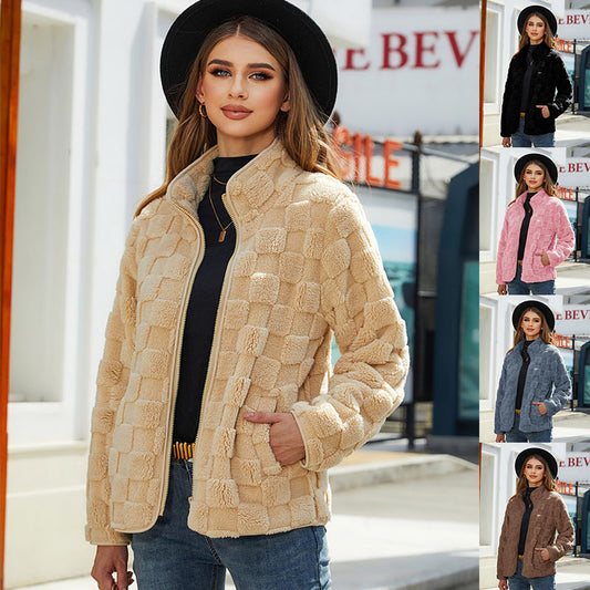 Woman wearing a beige textured jacket with a black hat and jeans, standing in front of a store with 'Bev' signage.