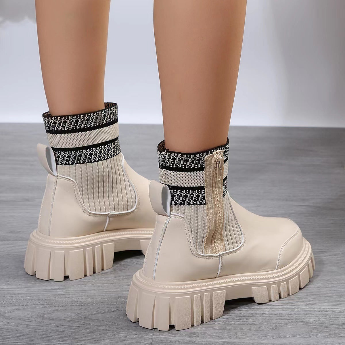 Beige ankle boots with patterned socks on a gray floor