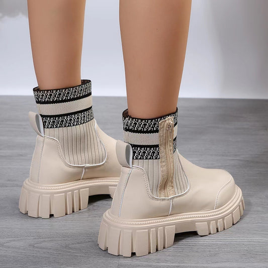 Beige ankle boots with patterned socks on a gray floor
