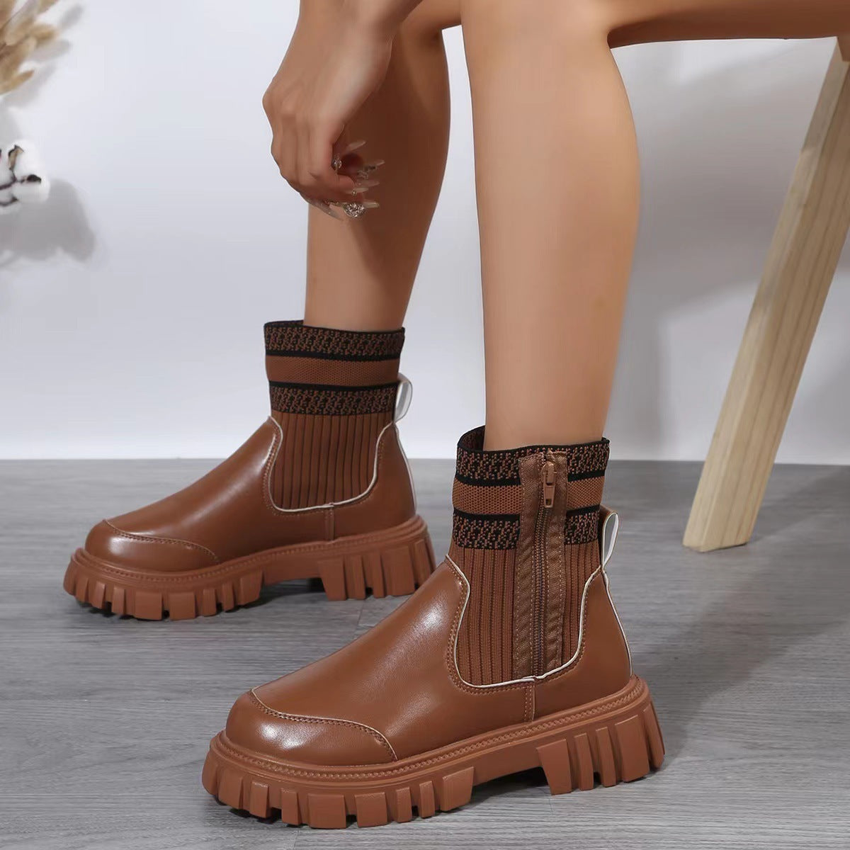 Brown platform boots worn with socks on a neutral background