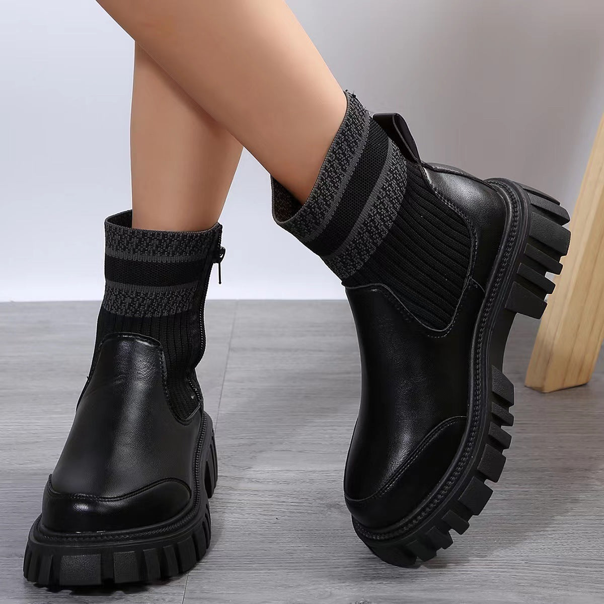 Black platform boots worn on a neutral background