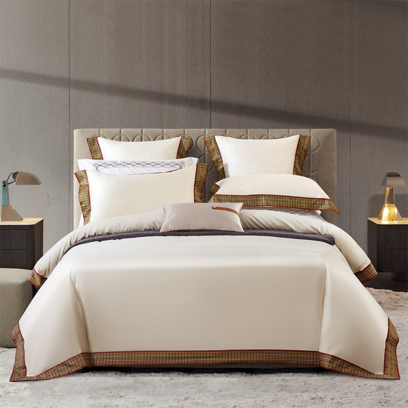 Premium bed linens and luxury bedding accessories in royal colors on grand king size bed - expensive sheets, blankets, and pillows by Millivan Supplies