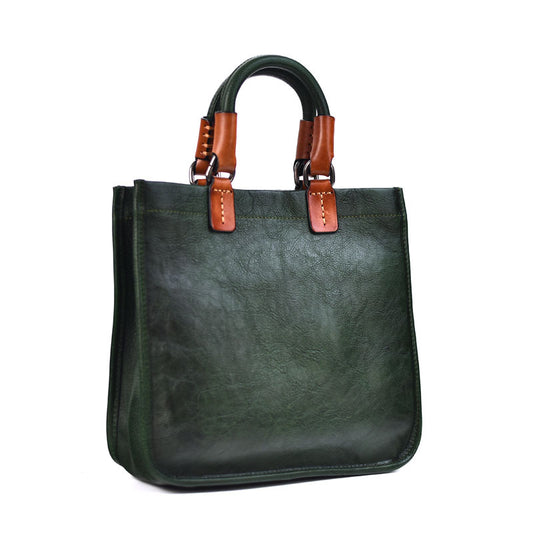 Green handbag with brown handles on a white background