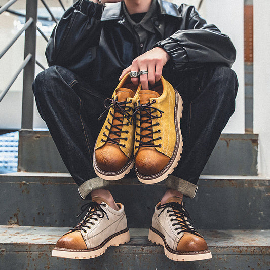 Person wearing brown and beige leather boots sitting on a metal staircase.