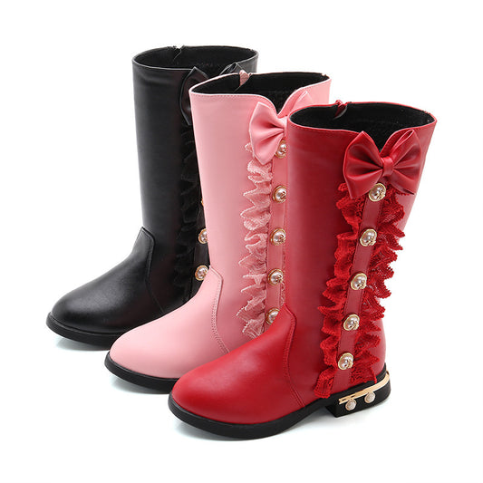 Black, pink, and red knee-high boots with decorative bows and ruffles on a white background