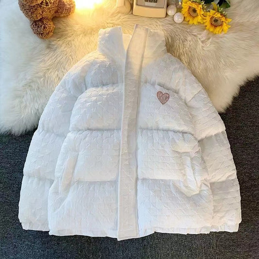 Light blue puffer jacket on a textured surface with decorative elements in the background