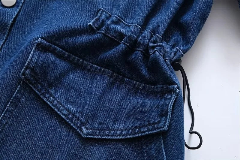 Close-up of a blue denim jacket with a drawstring detail on a white background
