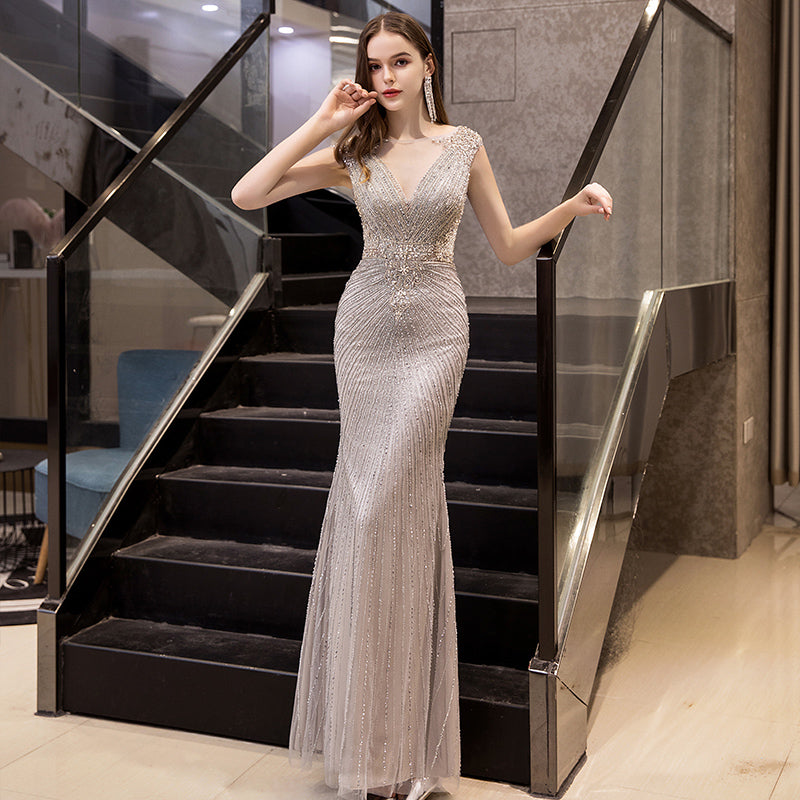 Woman in a silver evening gown standing on a staircase